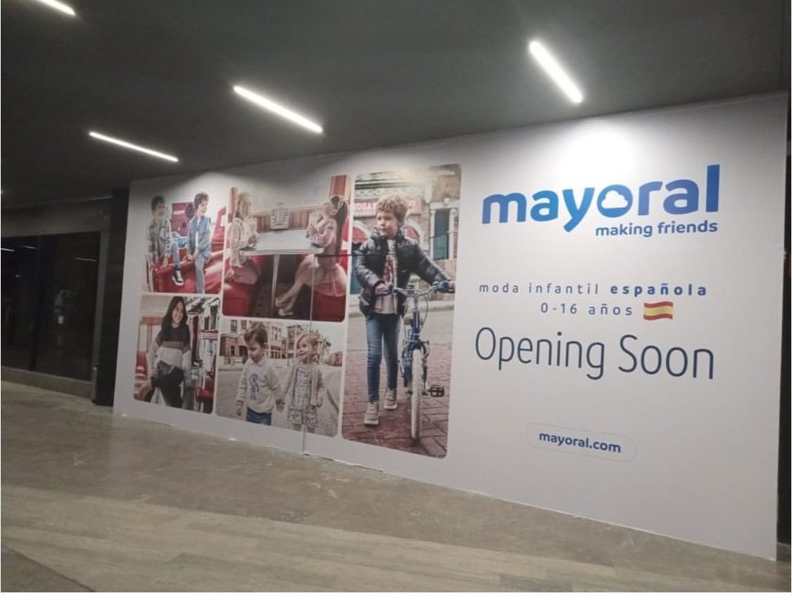 Vinil impreso cubriendo el tapial de una tienda en una plaza comercial